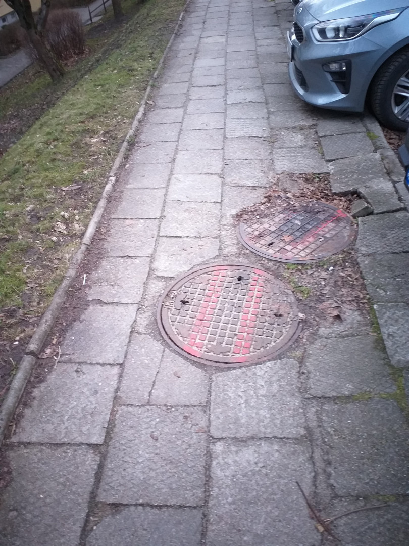 Zapadnięte studzienki kanalizacyjne w ciągu chodnika