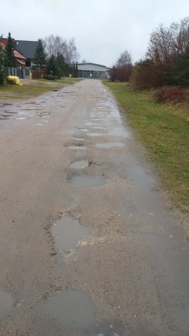 powierzchnia drogi i pobocza podziurawione kałużami